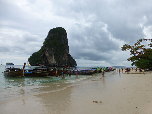 Long tails lining the beaching waiting to transport riders. 