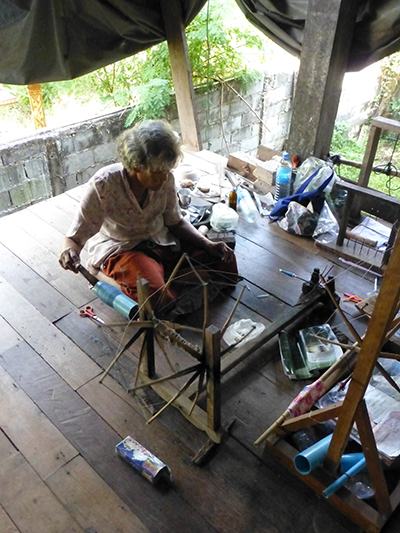 One of the weavers putting silk onto a bobbin. 