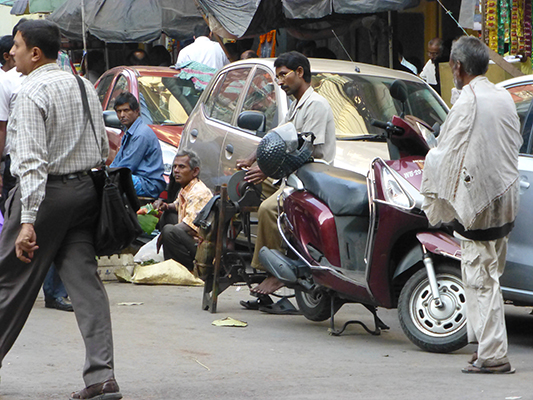 This guy is sharpening knives on a peddle powered sharpening wheel. 