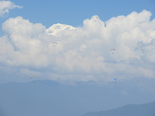Clouded peak with paragliders