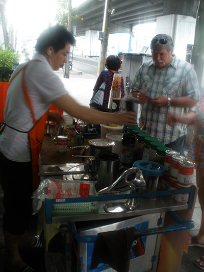 Phil ordering morning coffee at a coffee/tea cart. These guys put about three different forms of sugar into coffees and teas.